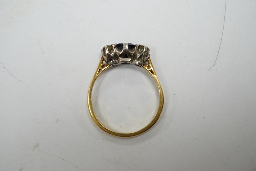 A yellow metal, sapphire and diamond set three stone ring, size Q, gross weight 3 grams. Condition - fair